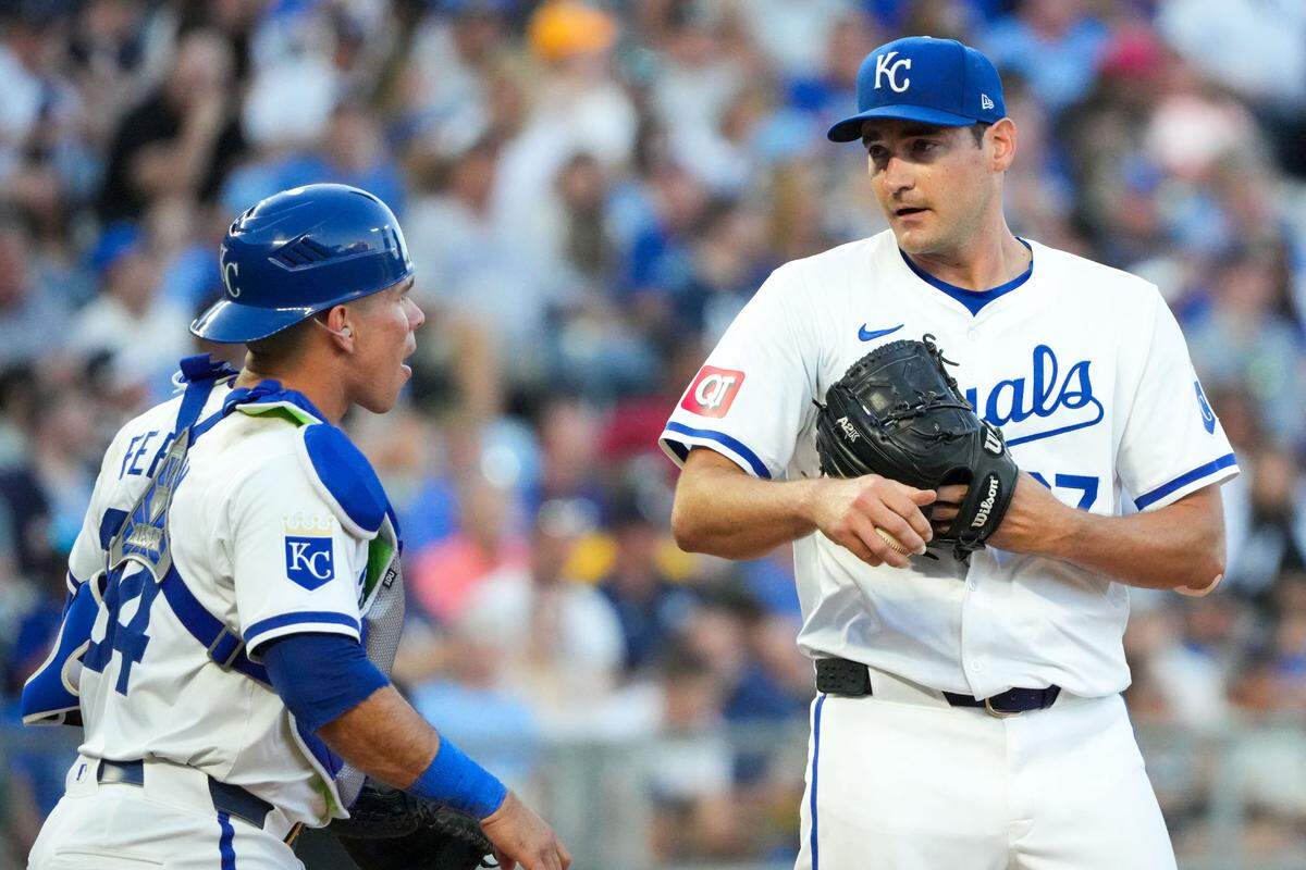 Kansas City Royals catcher Freddy Fermin (34) visits with starting pitcher Seth Lugo (67) on the mound in the fifth inning at Kauffman Stadium on June 10, 2024.