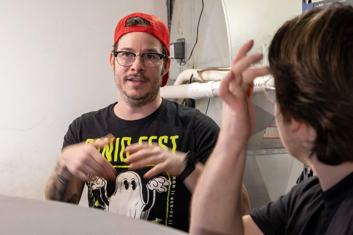 Adam Roberts, owner and operator of Screenland Armour Theatre, speaks with projectionist Julian Rossat before a 70mm screening of “Sinners” on Friday, March 27, 2026, in North Kansas City.