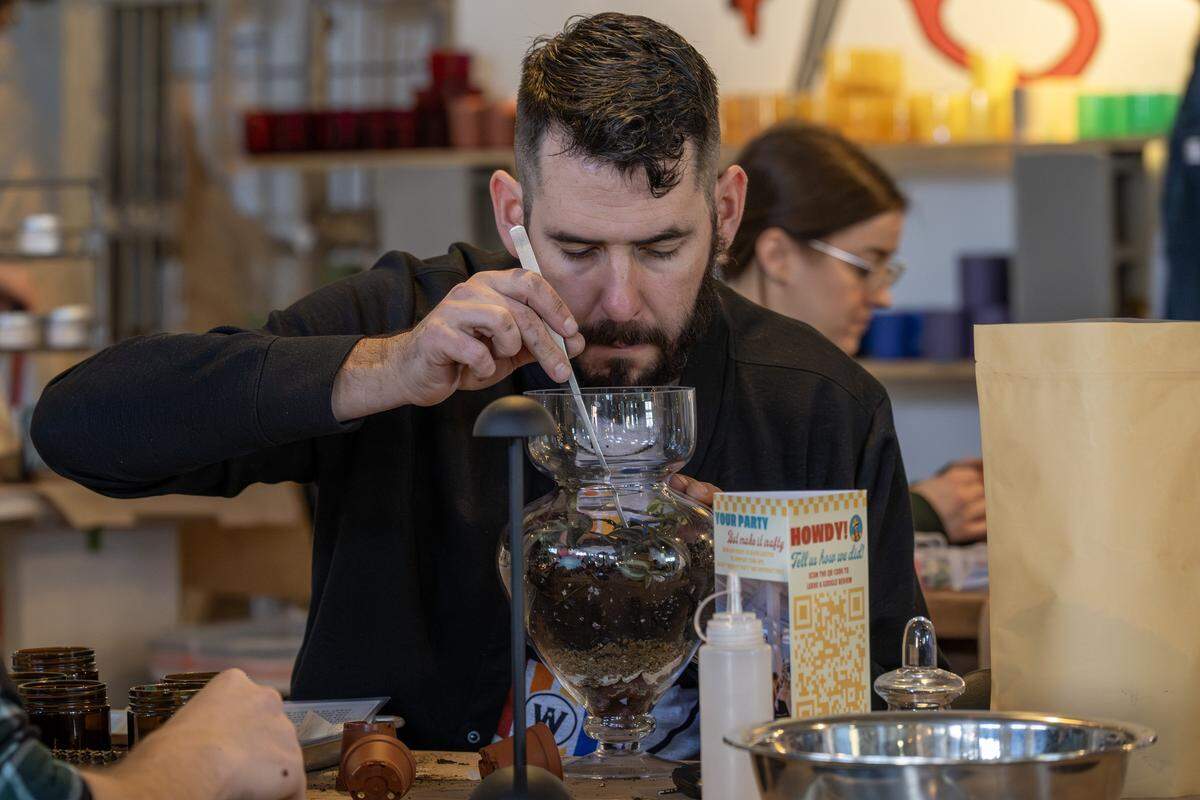 John Augustyn uses tweezers to arrange plants while making a terrarium at ADHDIY Craft Cafe on Saturday, Feb. 7, 2026, in Kansas City.