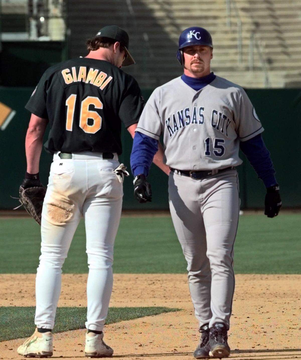 The Royals’ Jeremy Giambi, right, walked past his brother, Oakland Athletics first baseman Jason Giambi, after popping out in the ninth inning to end the game as the A’s defeated the Royals 12-3 on Sept. 19, 1999 in Oakland. Jason Giambi hit a two-run home run, his 32nd homer of the season, and drove in three runs while Jeremy had one hit in four at bats.