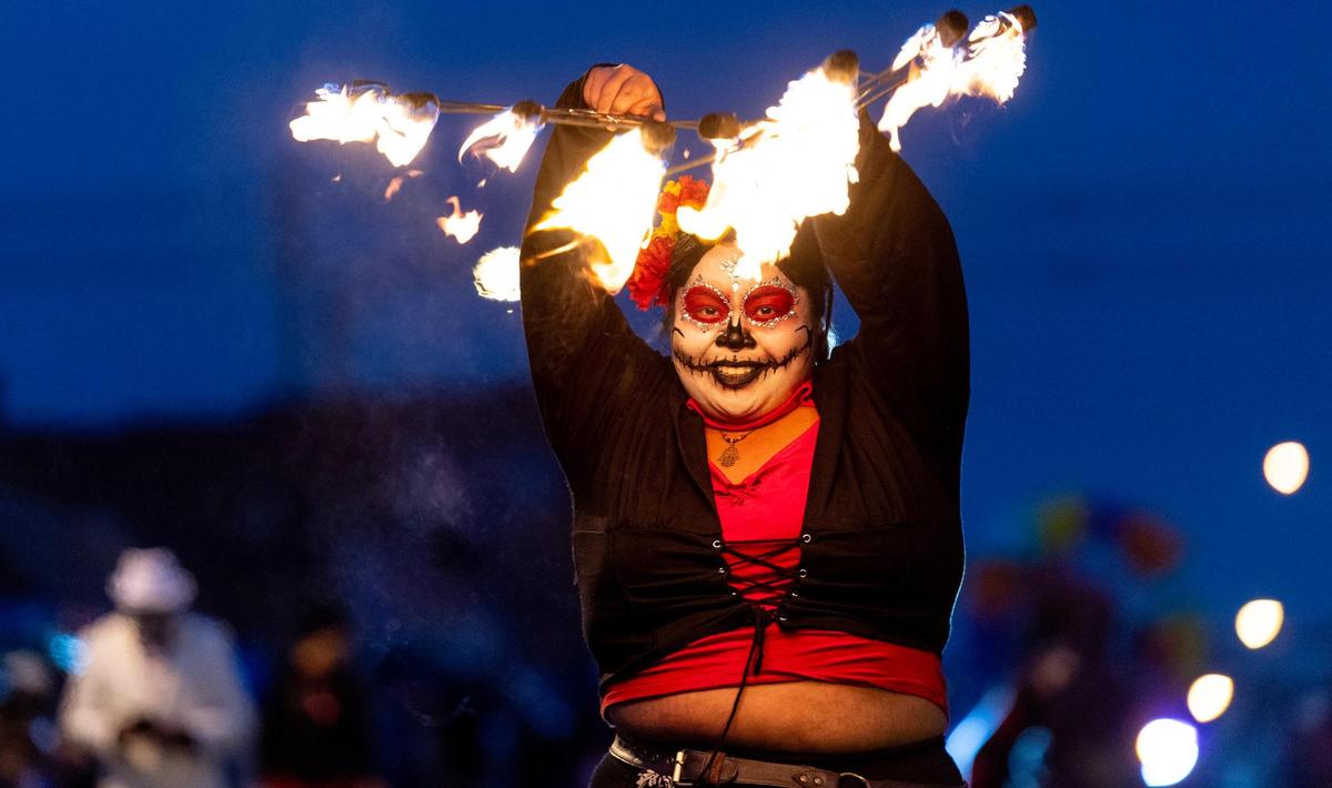Ashley Pacquiao performs with fire during the Día de los Muertos parade hosted by the Central Avenue Betterment Association on Saturday in Kansas City, Kan.