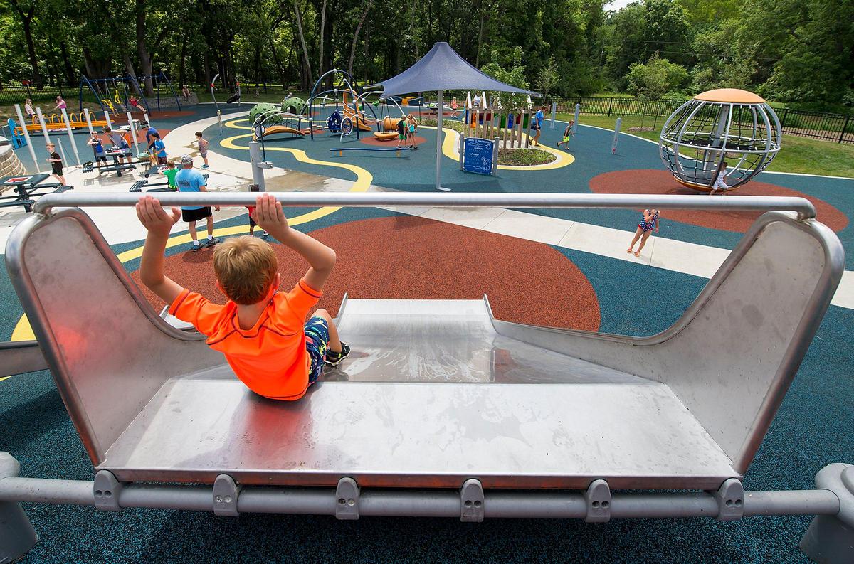 Despite the heat, children played on the slide and other equipment at the new inclusive playground at Shawnee Mission Park.