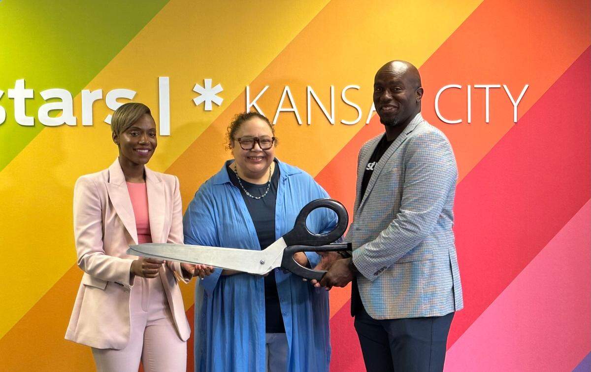 i.c.stars executive director Shamika Hogan (left), co-founder and president Sandee Kastrul (middle) and Chiefs Hall of Famer and national board member Will Shields pose after formally cutting the ribbon for a new office in KC.
