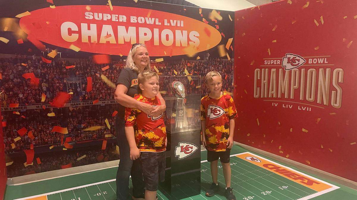 Deborah Sash and her grandchildren Wyatt Barry and Connor Barry take a picture with the Vince Lombardi Trophy at the Missouri Capitol.
