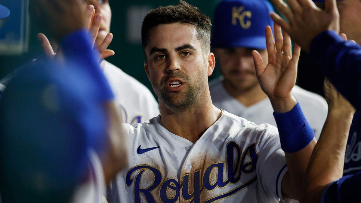 Kansas City Royals’ Whit Merrifield is congratulated in the dugout after scoring from third base on a wild pitch by Minnesota Twins pitcher John Gant during the first inning of a baseball game in Kansas City, Mo., Friday, Oct. 1, 2021. (AP Photo/Colin E. Braley)