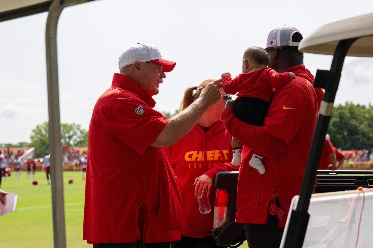 Kansas City Chiefs head coach Andy Reid shakes hands with a very young fan at training camp in St. Joseph.
