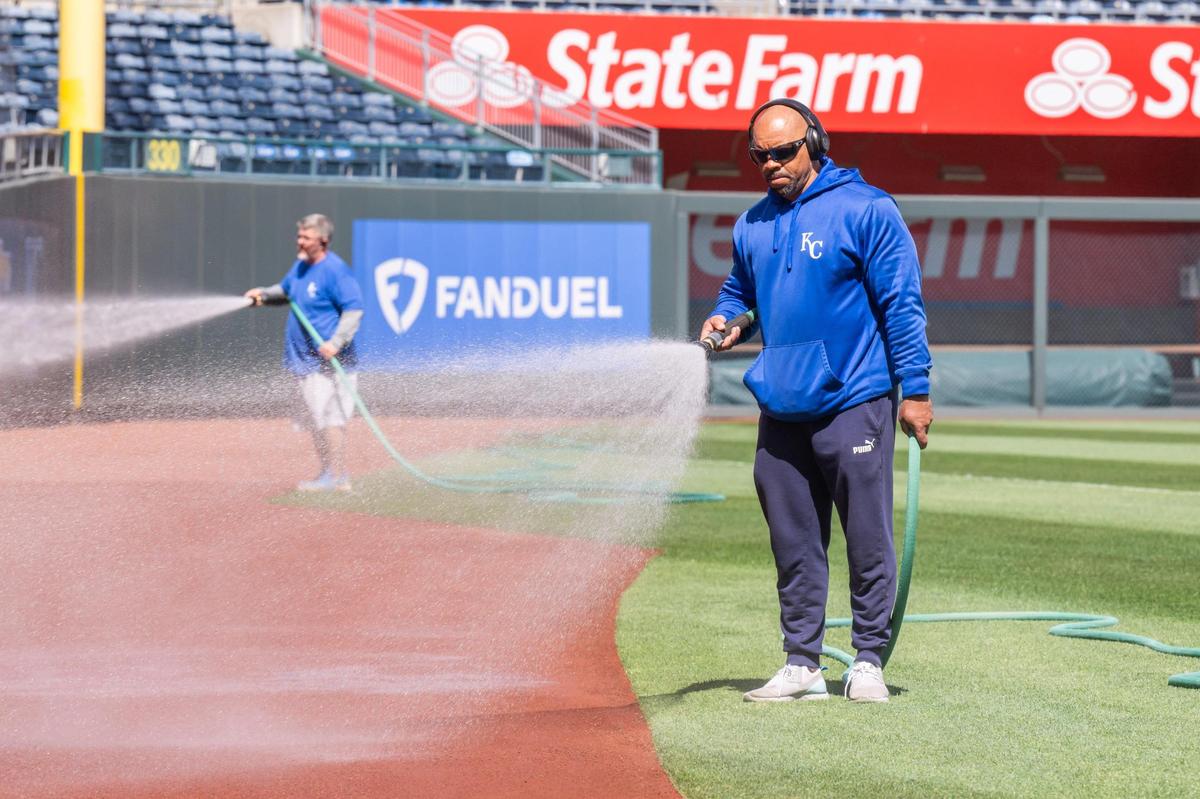 Kansas City Royals grounds keepers spray water on the dirt surround the baseball diamond at Kauffman Stadium on Tuesday, March 25, 2025.