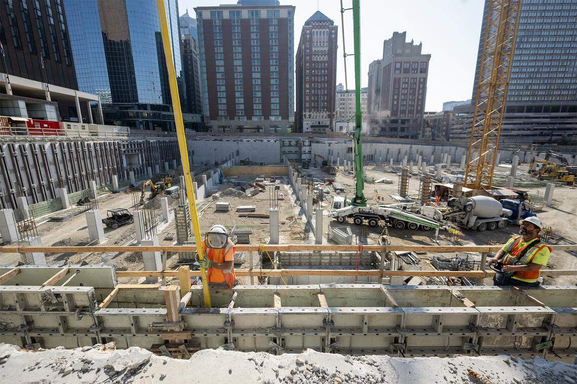A worker in August guides concrete into the west all of the new Barney Allis Plaza.