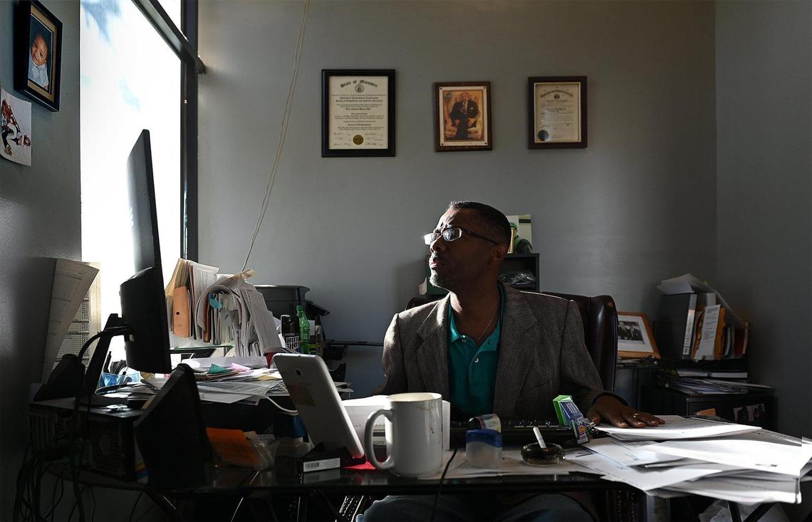 Funeral director Malcolm Morris works on correspondence and other business before the doors open at Elite Funeral Chapel in Kansas City. Morris has stopped providing funeral services for homicide victims.