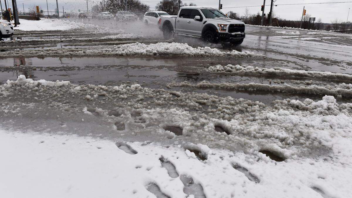 A passing truck splashes through piles of slushy snow Thursday near the intersection of 87th St. and I-35 in Lenexa. Several inches of wet snow fell overnight greeting commuters with slick roads.