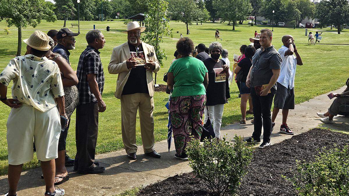 People attend the ceremony unveiling new granite historical markers in McCoy Park.
