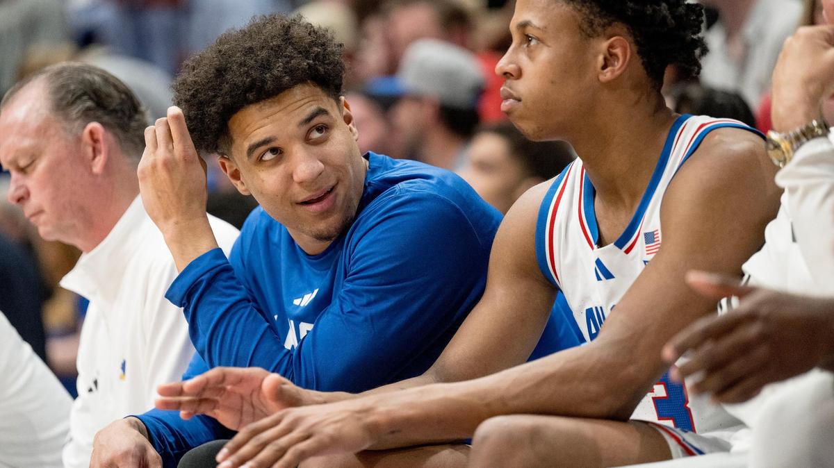 Kansas Jayhawks guard Kevin McCullar Jr. talks to guard Elmarko Jackson (13) on the bench during an NCAA college basketball game against the Texas Longhorns on Saturday, Feb. 24, 2024, in Lawrence.