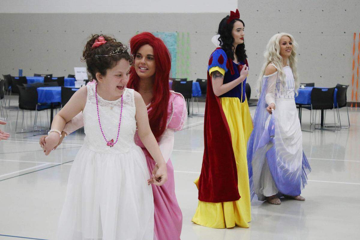 Nori Childers, 12, dances with Jessica Laughlin as Ariel, while Erin White and Ciara Cohorst, as Snow White and Elsa, enjoy the adaptive royal ball program at the Shawnee Civic Center.