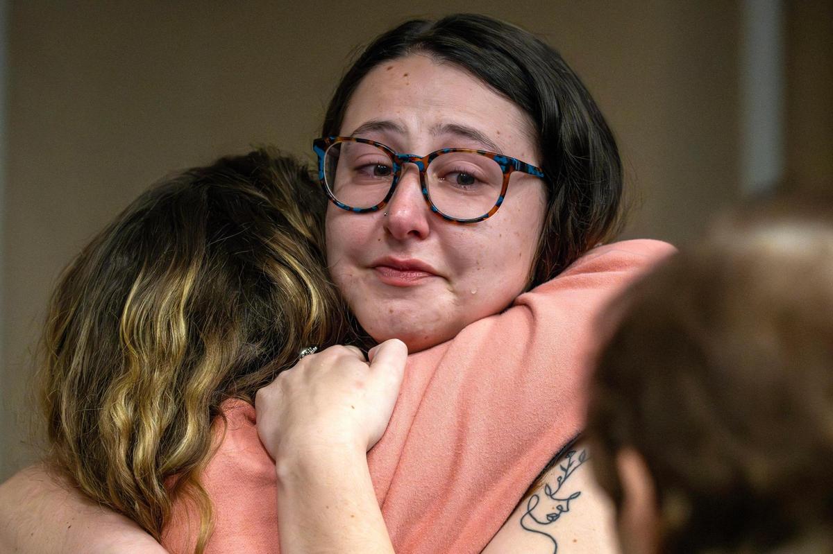 Amanda Birger, right, a close friend of Sarah Milgrim and Yaron Lischinsky, embraces her sister Emily Birger in tears after speaking during a vigil for Milgram and Lischinsky at the Jewish Community Center’s Social Hall on Thursday, May 22, 2025, in Overland Park. Milgram and Lischinsky were killed outside the Capital Jewish Museum in Washington, D.C., on Wednesday, May 21.