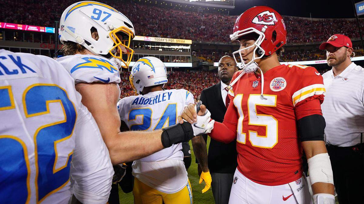 Kansas City Chiefs quarterback Patrick Mahomes (15) meets with Los Angeles Chargers linebacker Joey Bosa (97) following a game at GEHA Field at Arrowhead Stadium.
