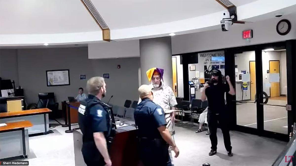 Police officers escorted Michael Eravi out of Lawrence City Hall and told him he was being cited for trespassing.