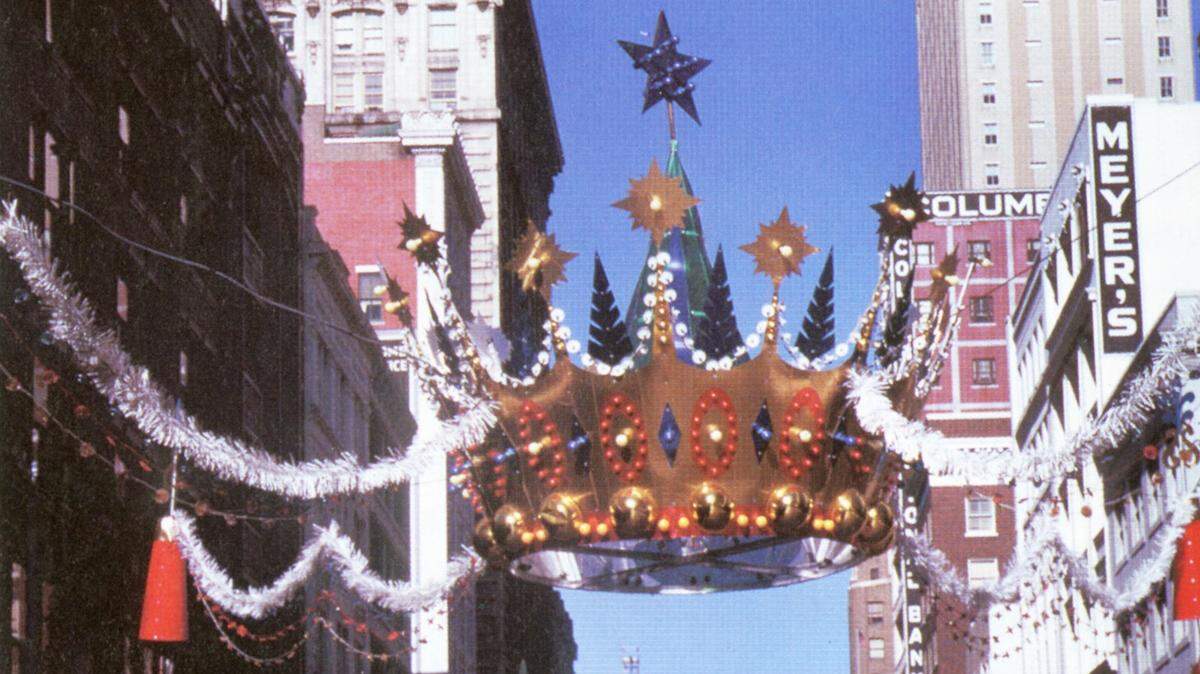 A Christmas crown suspended above a busy downtown Kansas City intersection – ca. 1960s