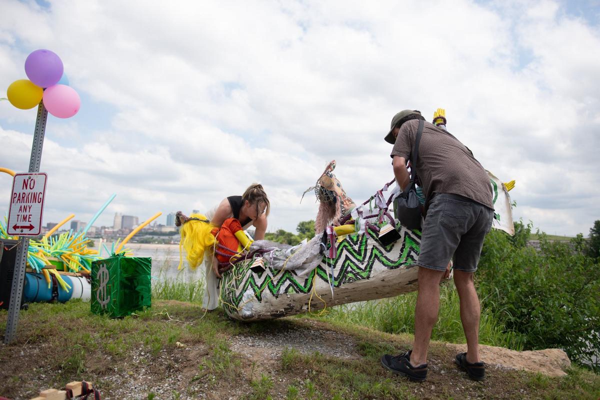 Particpants in Kawsmouth River Carnival boat parade launch their decorated boat at Kaw Point Park.