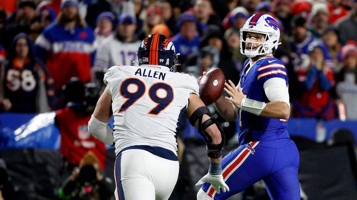 Buffalo Bills quarterback Josh Allen (17) looks downfield as he is pressured by Denver Broncos defensive end Zach Allen (99). Allen threw for 177 yards and a touchdown.