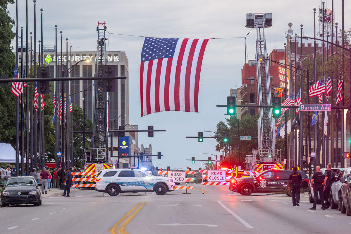A flag is hung across 7th Street during a candlelight vigil held for slain sheriff’s deputy Elijah Ming outside the Wyandotte County Courthouse on Wednesday. The nearly nine-year veteran died in the line of duty on Saturday.
