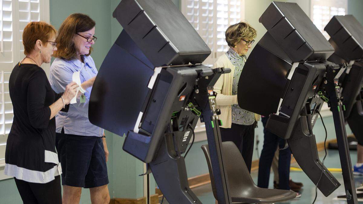 Election judge Liz Graham (left) helped voter Liz Pendleton become familiar with a new voting machine Tuesday at Colonial Church in Prairie Village.