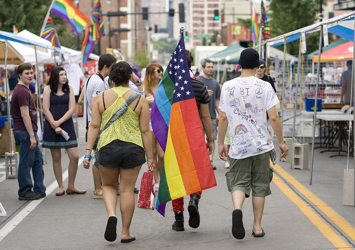 Friends Felecia Warden, 17, of Kansas City, Ethen Galvin (center, with flag) of Kansas City, Kansas, and Trevor Doyal of Kansas City walk through the Power & Light District in 2012 during the 34th annual Pride Week.