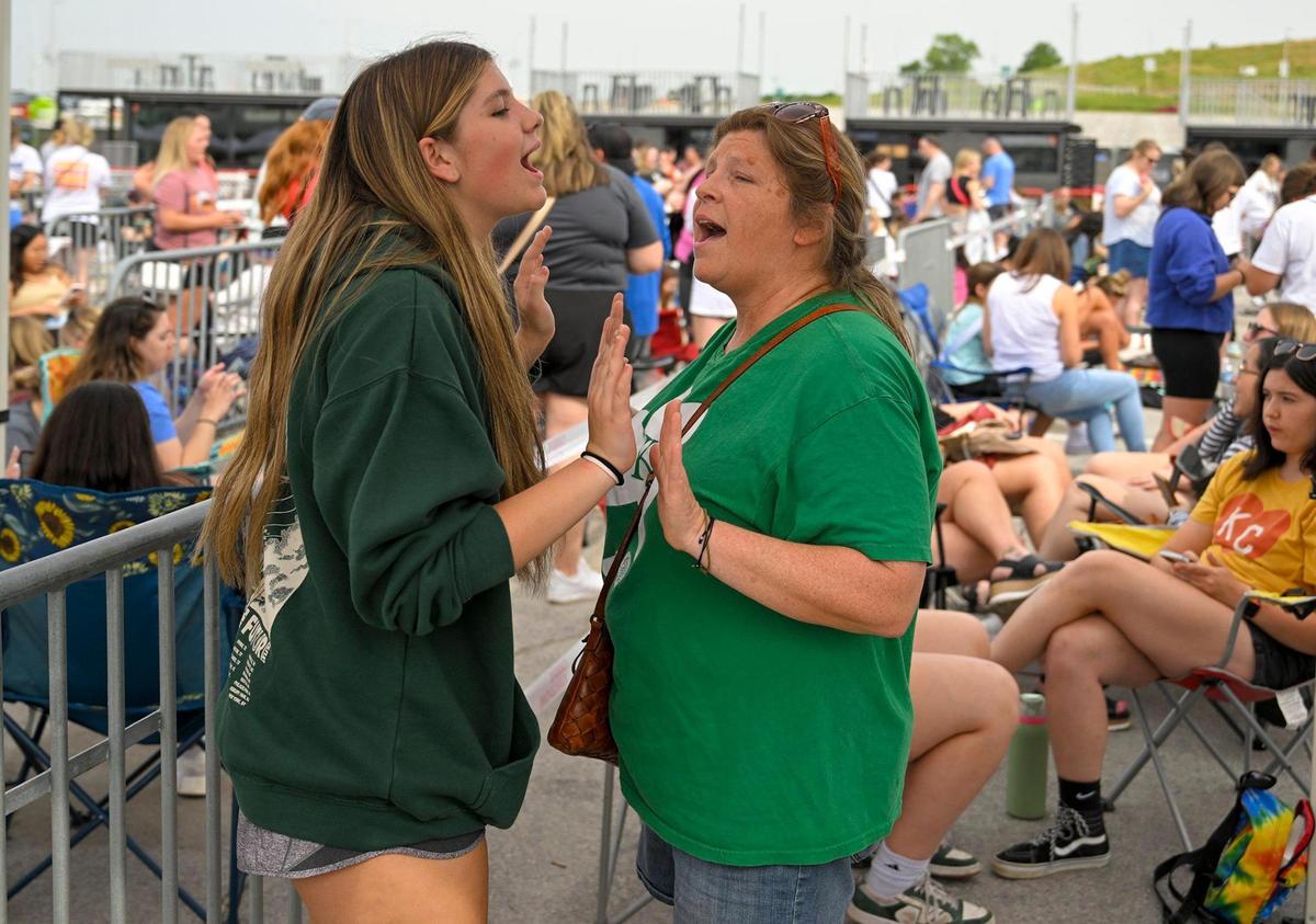 Swifties, fans of Taylor Swift, including Taylor Nichol, 14, and her mother, Pam Nichol of Lone Jack, Missouri, danced and sang to music by Taylor Swift playing over loud speakers as they waited in line buy The Eras Tour merchandise on Thursday, July 6, 2023, at Arrowhead Stadium in Kansas City. The pair will be attending both concerts.