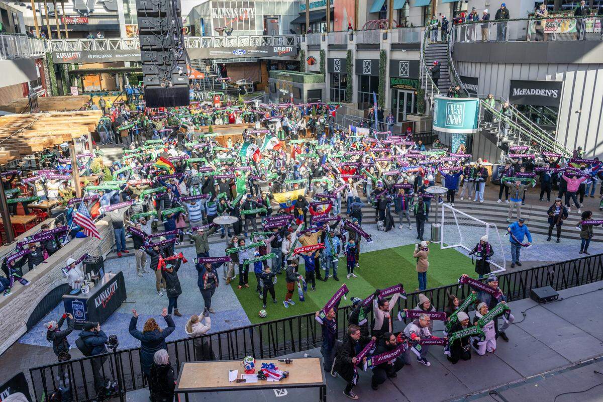 Fans cheer and lift scarves and flags during the FIFA World Cup draw watch party at the Power & Light District on Friday, Dec. 5, 2025, in Kansas City.
