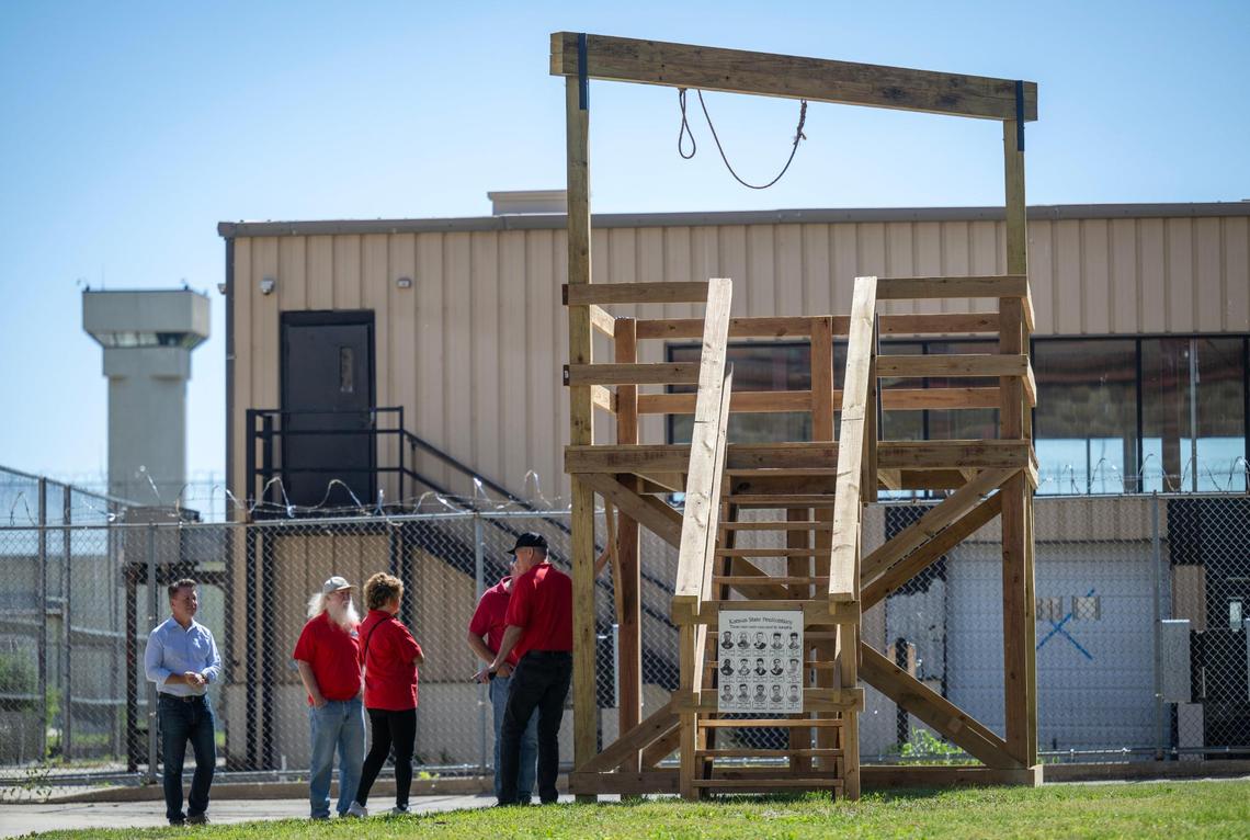 Visitors and members of the Lansing Historical Society and Museum talk as they view a reproduction of the gallows which were used for executions at the former Kansas State Penitentiary from 1944 to 1965.