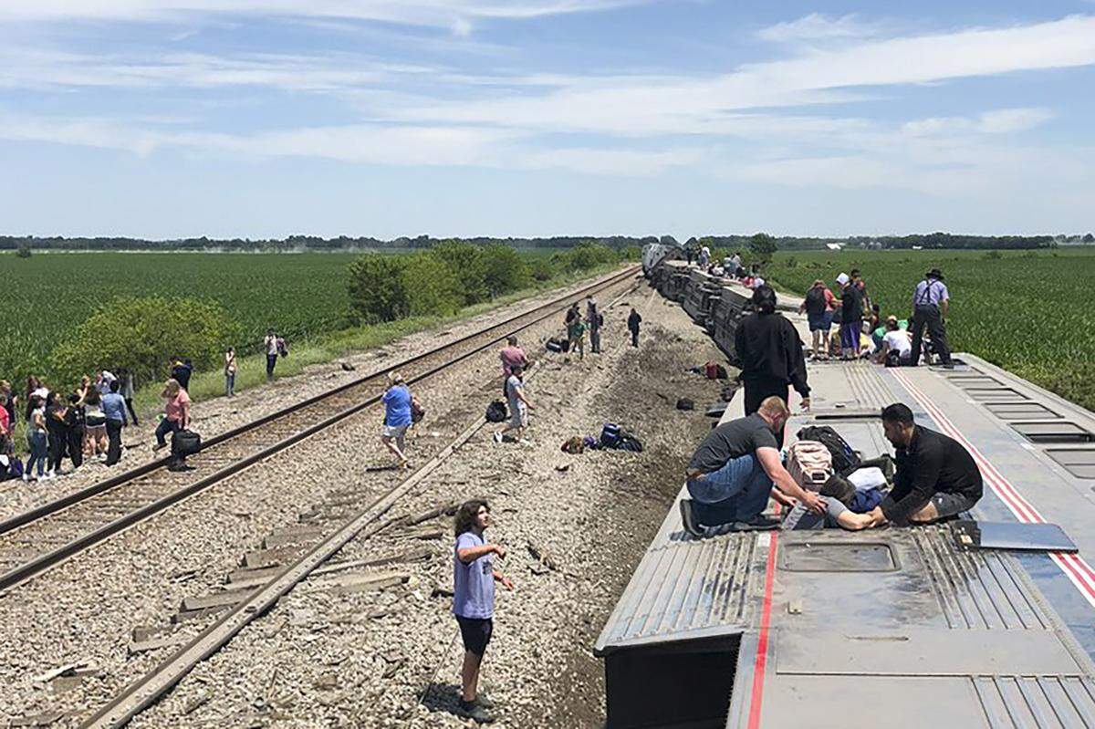 In this photo provided by Dax McDonald, an Amtrak passenger train lies on its side after derailing near Mendon, Mo., on Monday, June 27, 2022. The Southwest Chief, traveling from Los Angeles to Chicago, was carrying about 243 passengers when it collided with a dump truck near Mendon, Amtrak spokeswoman Kimberly Woods said.