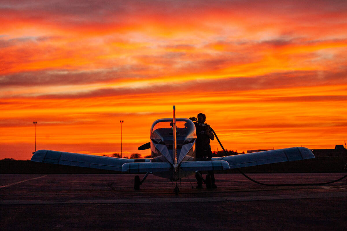 Mujahid Abdulrahim, a Kansas City area pilot and assistant professor at the University of Missouri—Kansas City, stands outside his plane during a morning sunrise.
