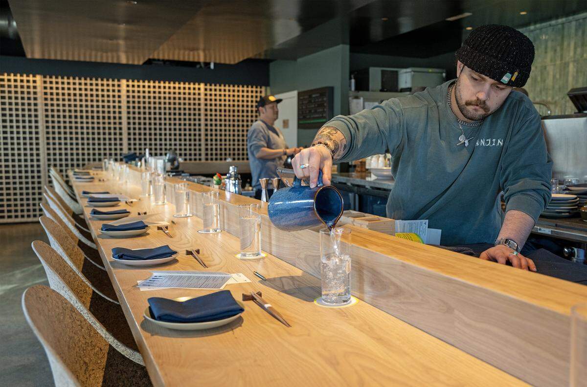 Server George Baron fills water glasses before the start of the dinner service at Anjin, a 20-seat Japanese Izakayas-style restaurant, on Monday, March 16, 2026, in Kansas City.