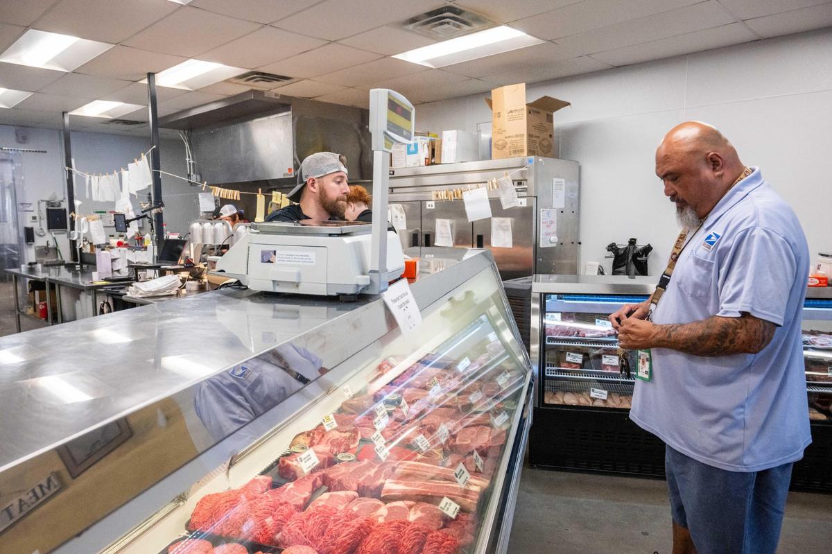 Eric Shoemaker helps assist Junior Perez at the fresh meat counter at The Upper Cut on Thursday, July 24, 2025 in Liberty. The butcher shop and restaurant raises, ages, and cuts their own in-house beef. They also sell fresh meat and prepared sandwiches and entrees.