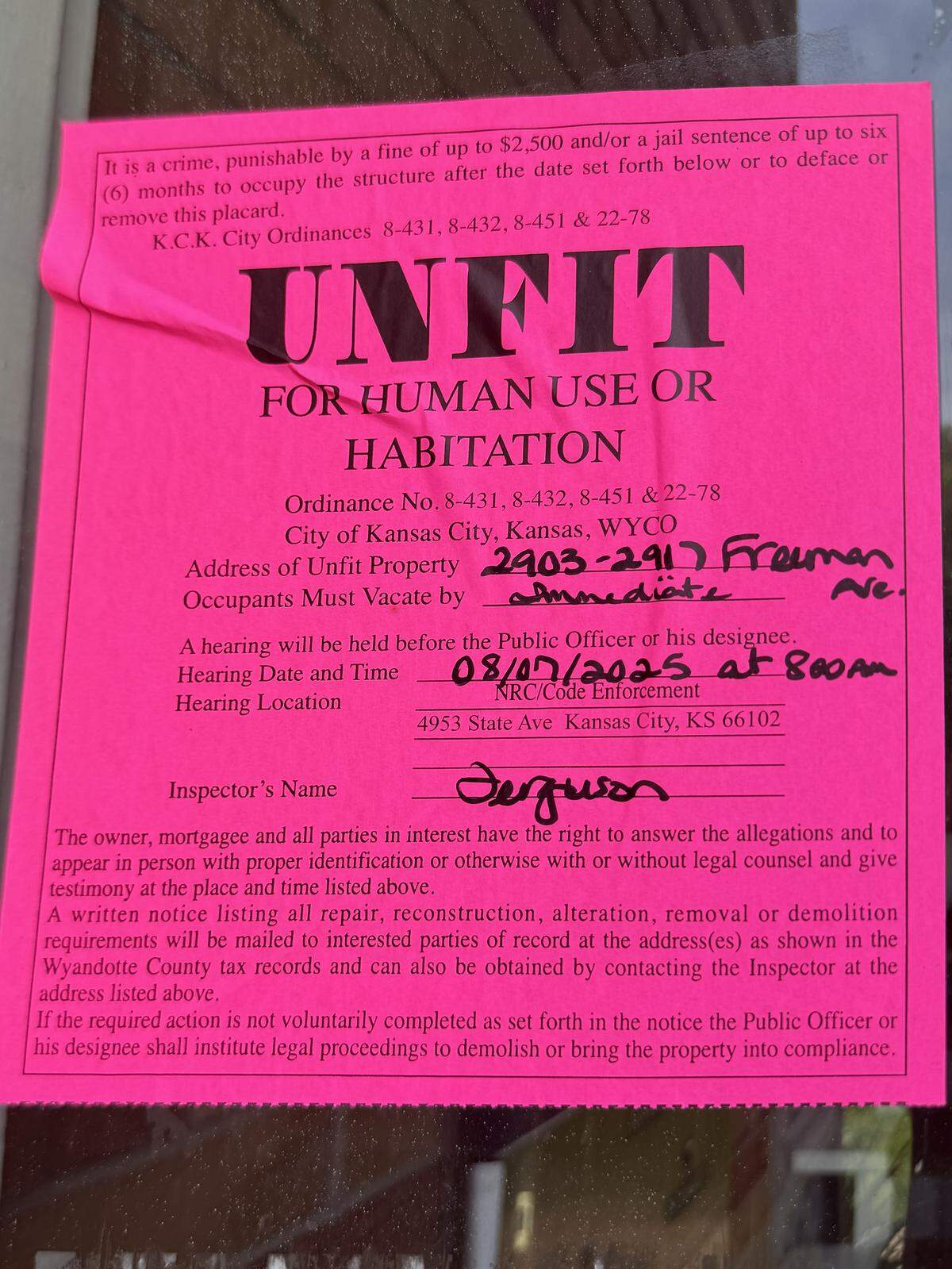 A notice reading “UNFIT FOR HUMAN USE OR HABITATION” is taped to the door.