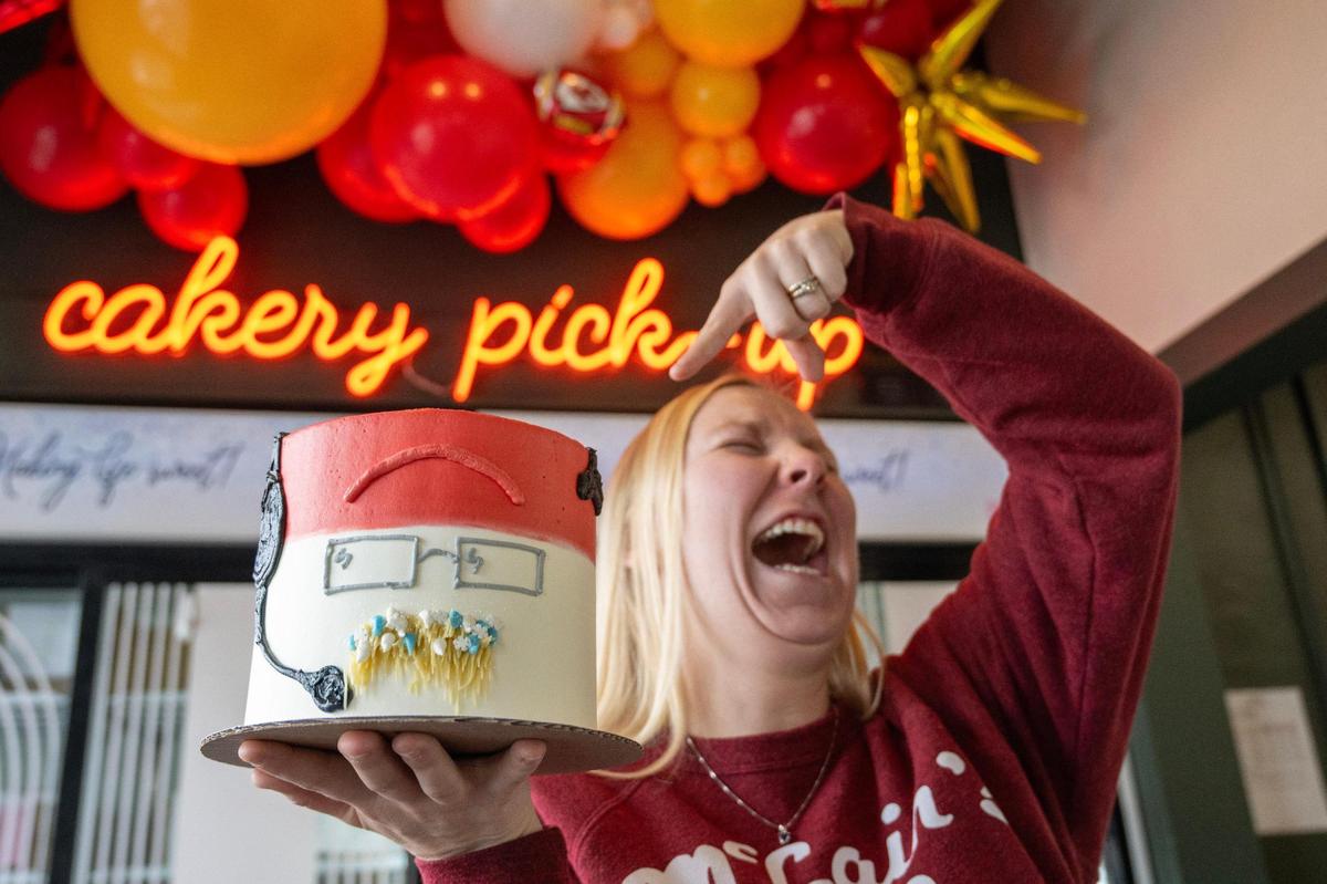 Cassidy Garr, director of guest experience, points and laughs while showcasing the Andy Reidcicle cake at McLain’s Bakery in Kansas City. McLain’s devised the cake as a playful nod to Kansas City Chiefs head coach Andy Reid’s icicle mustache, showcased during the AFC Wild Card game against the Miami Dolphins.
