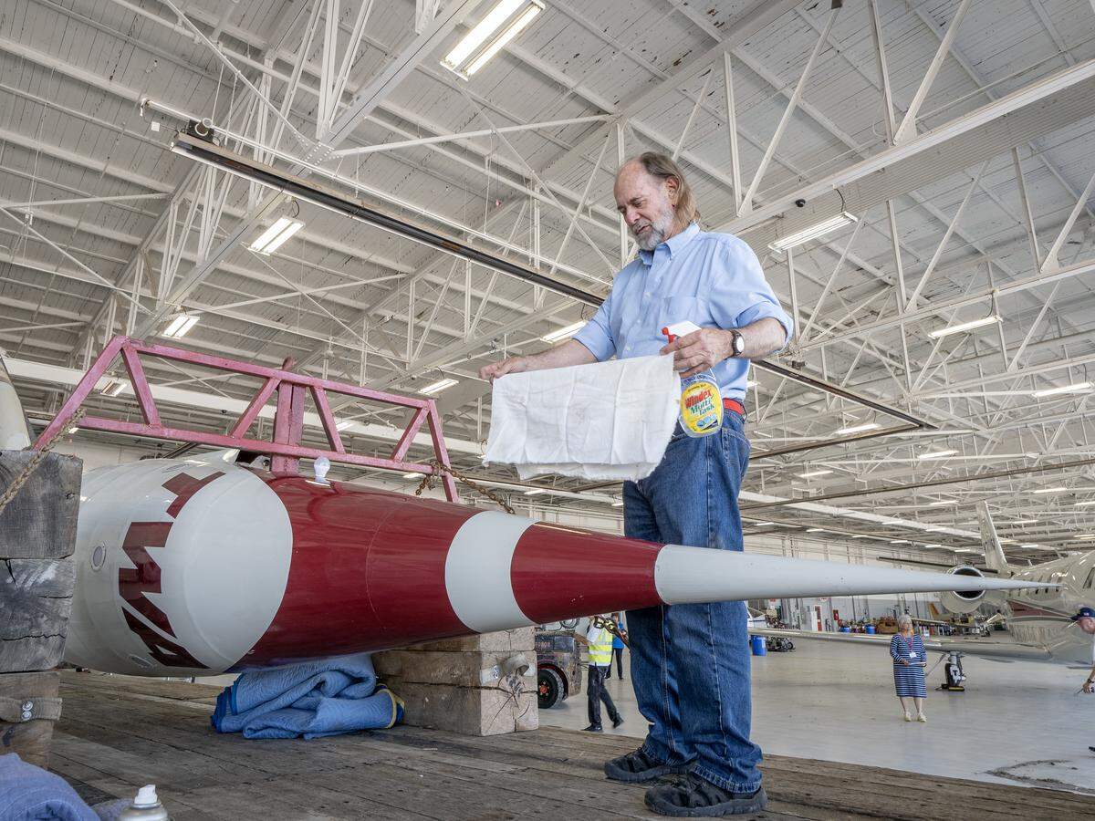 TWA Moonliner II owner Dan Viets helped clean the dusty rocket after it was moved inside the TWA Museum on Saturday.