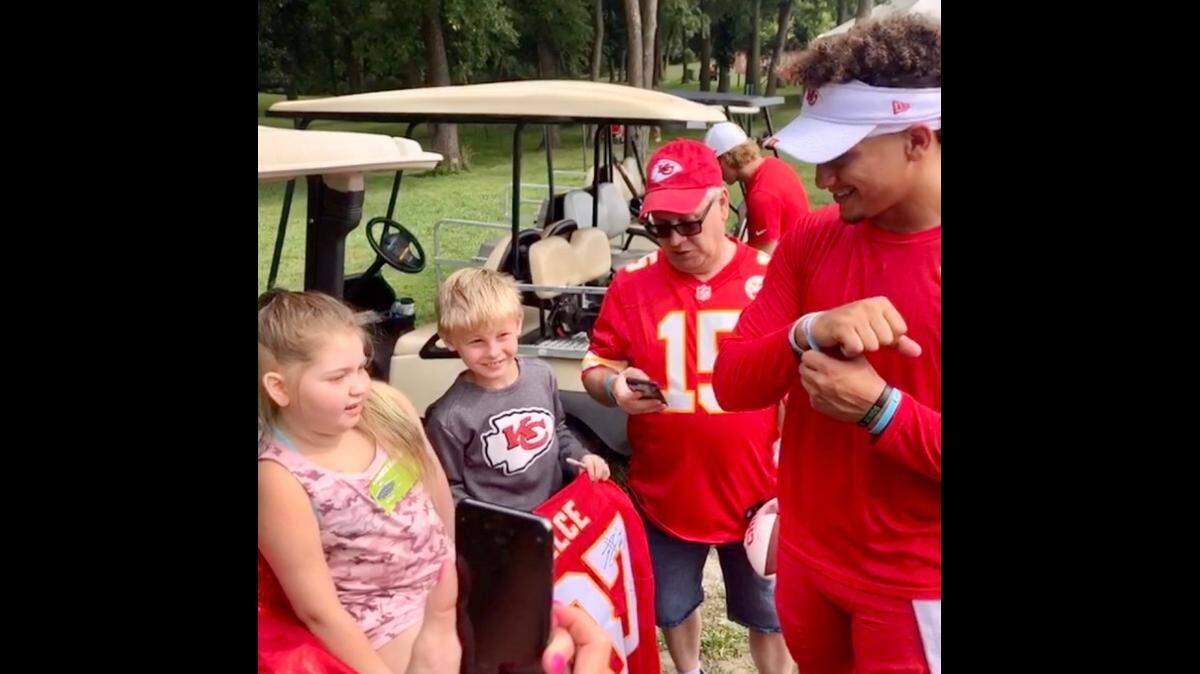 After receiving the bracelet from 10-year-old Whitney Wells (left) at training camp, Chiefs quarterback Patrick Mahomes immediately put it on his wrist.