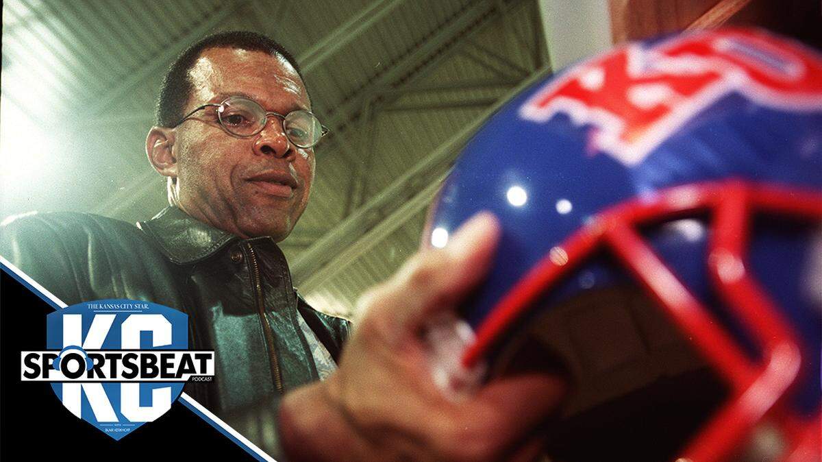 Pro Football Hall of Fame and KU alum Gale Sayers autographs a KU helmet at the Overland Park Trade Center in 2001.