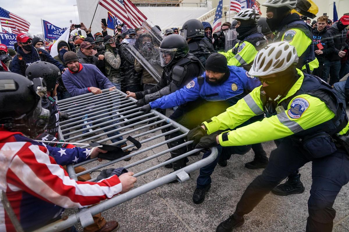 Trump supporters try to break through a police barrier, Wednesday, Jan. 6, 2021, at the Capitol in Washington. As Congress prepares to affirm President-elect Joe Biden’s victory, thousands of people have gathered to show their support for President Donald Trump and his claims of election fraud.(AP Photo/John Minchillo)