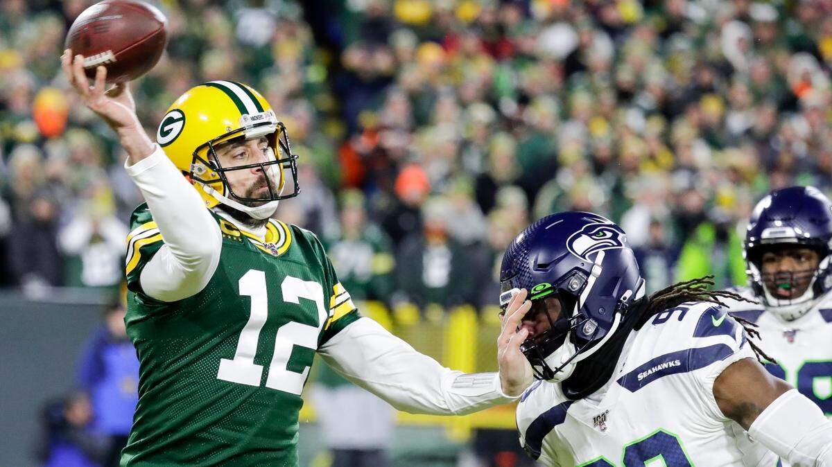 Green Bay Packers’ Aaron Rodgers passes while being rushed by Seattle Seahawks’ Jarran Reed during the first half of an NFL divisional playoff football game Sunday, Jan. 12, 2020, in Green Bay, Wis. (AP Photo/Darron Cummings)