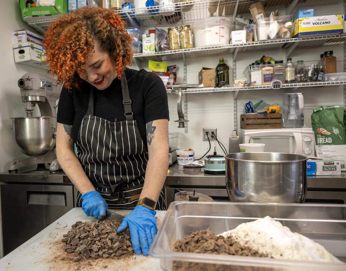 Pastry chef Nichole Taylor cuts chocolate while preparing chocolate cookies at Sister Anne's Coffee and Records Thursday, Dec. 4, 2025, in Kansas City.