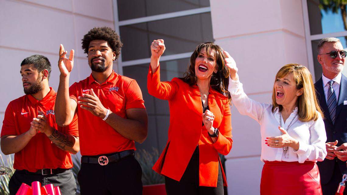 UNLV football players, from left, Giovanni Fauolo, and Armani Rogers cheer alongside UNLV athletic director Desiree Reed-Francois and UNLV acting president Marta Meana as they sing the UNLV fight song following the ribbon cutting of the Fertitta Football Complex at UNLV in Las Vegas on Thursday, Oct. 3, 2019. (Chase Stevens/Las Vegas Review-Journal) @csstevensphoto