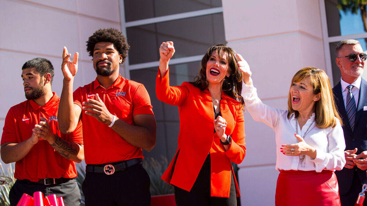 UNLV football players, from left, Giovanni Fauolo, and Armani Rogers cheer alongside UNLV athletic director Desiree Reed-Francois and UNLV acting president Marta Meana as they sing the UNLV fight song following the ribbon cutting of the Fertitta Football Complex at UNLV in Las Vegas on Thursday, Oct. 3, 2019. (Chase Stevens/Las Vegas Review-Journal) @csstevensphoto