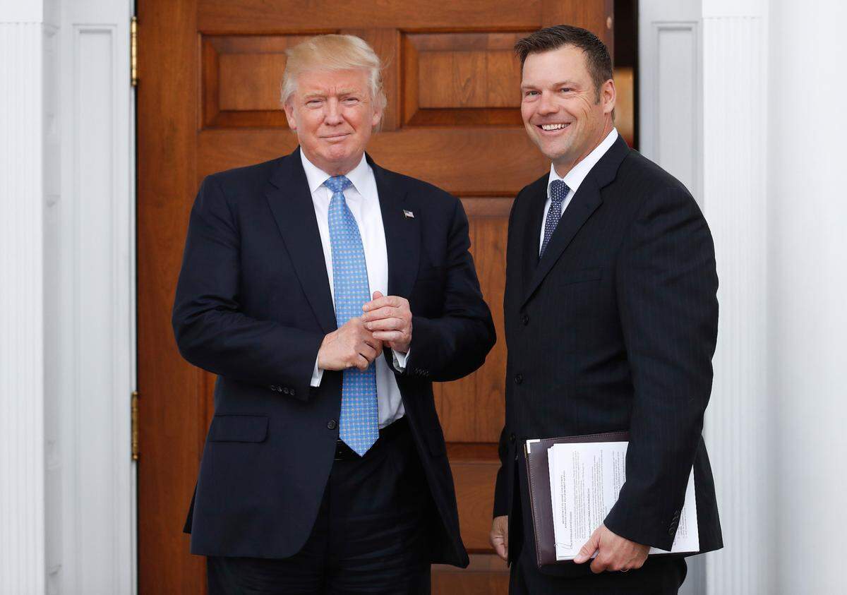 in this 2016, file photo, then Kansas Secretary of State Kris Kobach stands with President-elect Donald Trump at the Trump National Golf Club Bedminster clubhouse in Bedminster, N.J. 