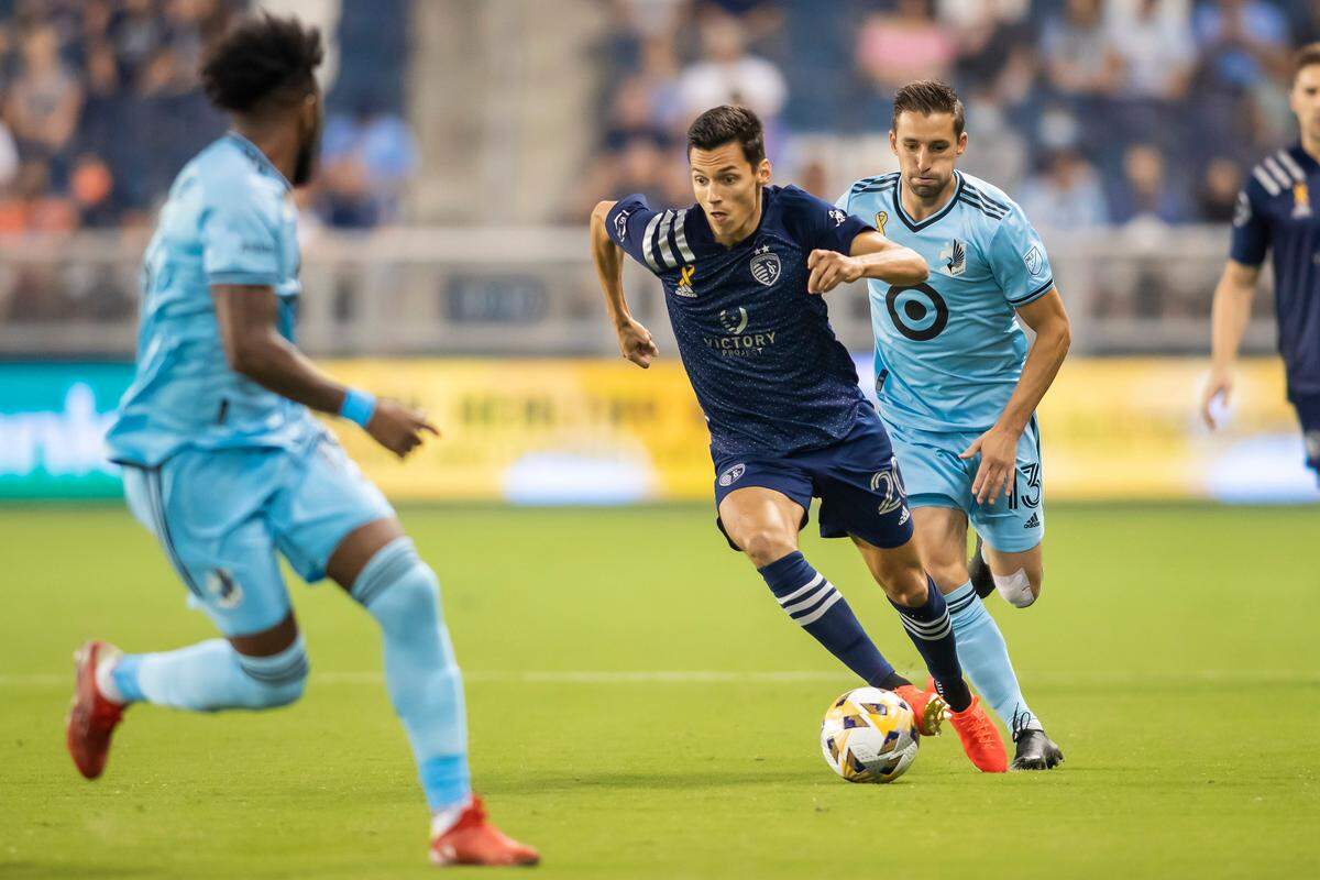 Sporting Kansas City forward Daniel Salloi splits a pair defenders during Wednesday night’s match against Minnesota United at Children’s Mercy Park in Kansas City, Kan. Salloi scored his 13th goal of the season.