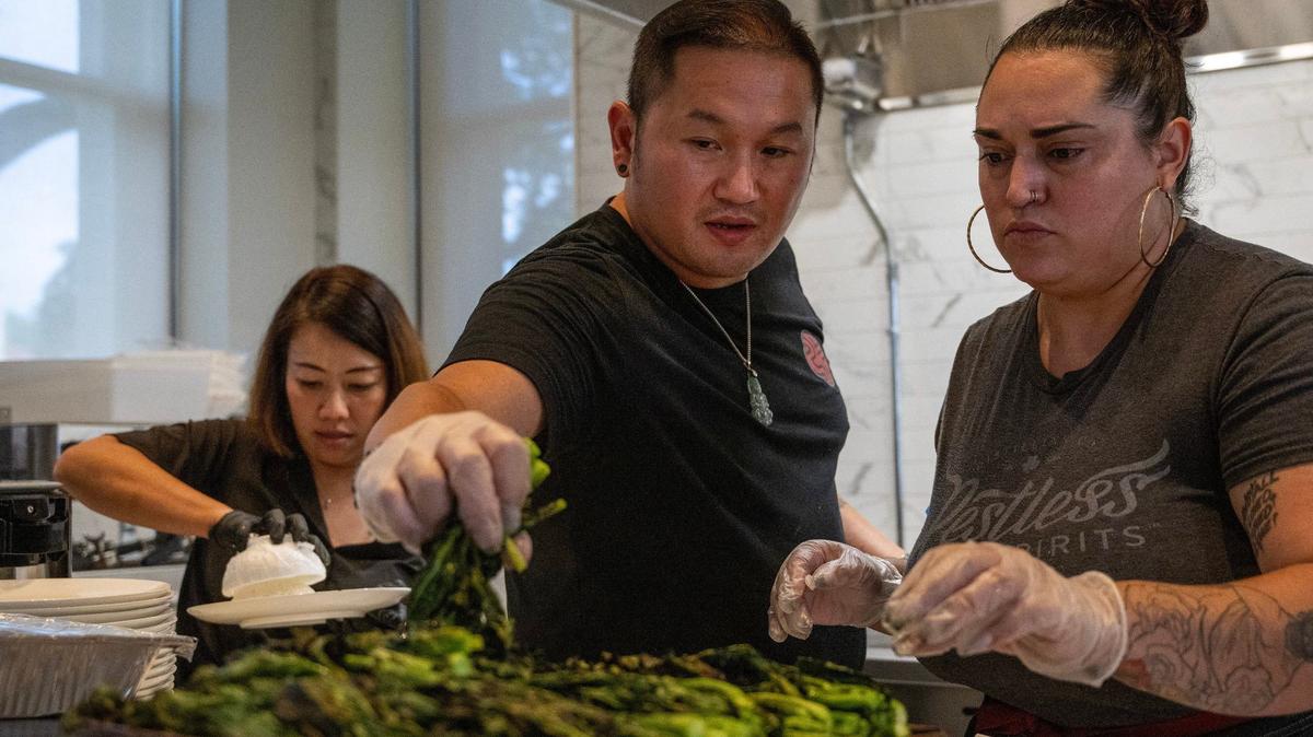 James Chang, center, inspects vegetables while preparing a dish during ‘Puen,’ a three-course meal event at the Kansas City Museum on Thursday, Aug. 29, 2024.