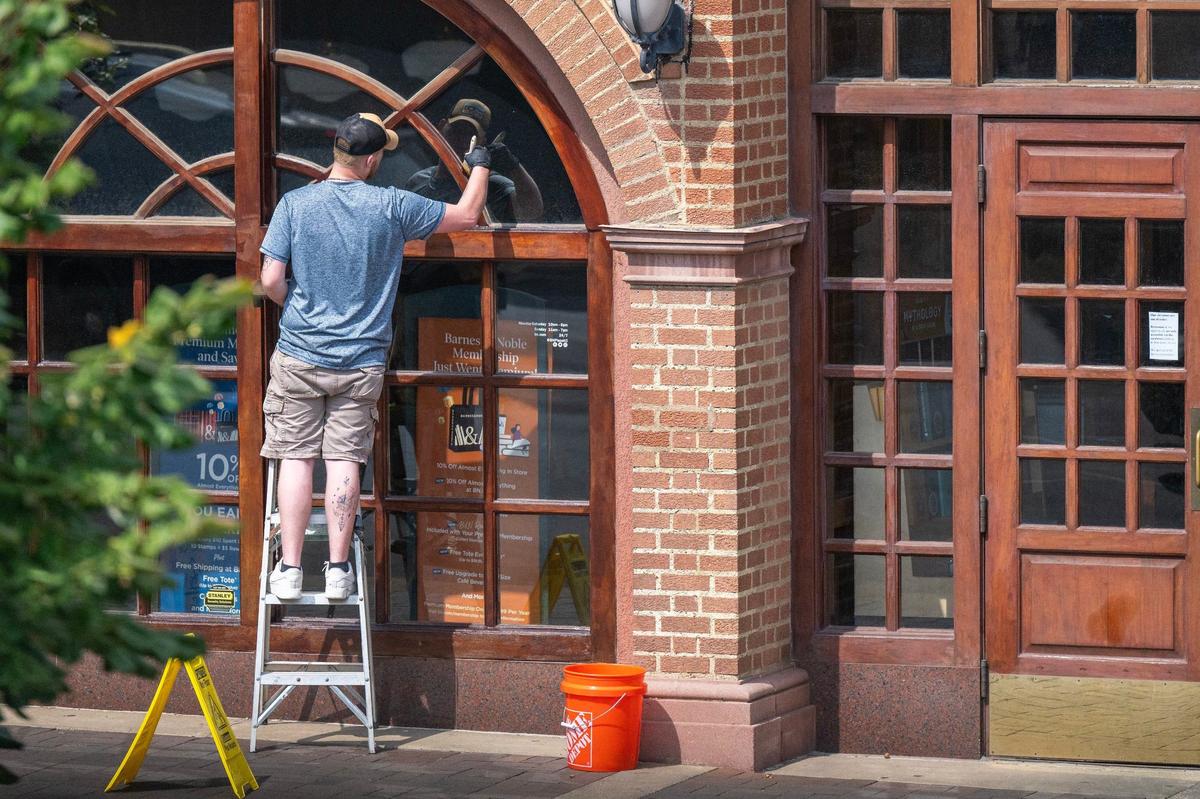 A worker restains window trim outside Barnes & Noble at the Country Club Plaza.