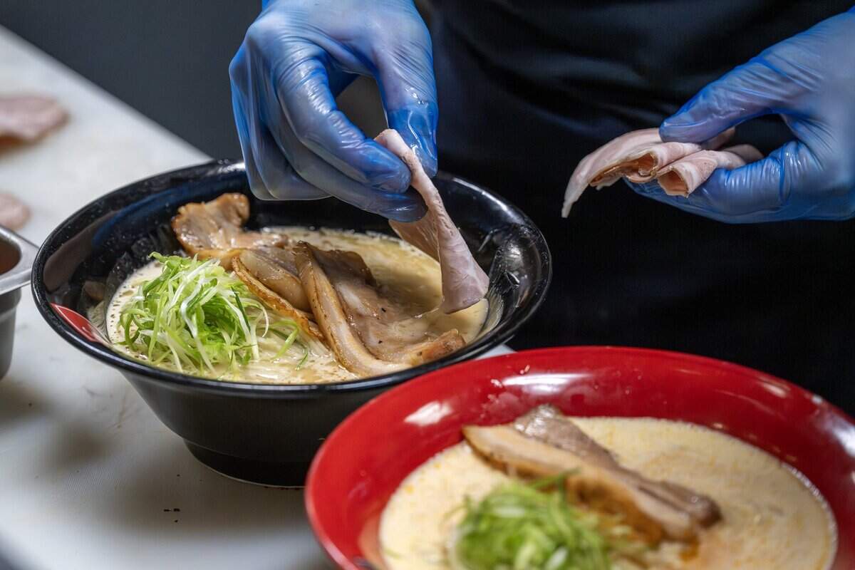 A chef places pork belly on a bowl of ramen to serve at KC Craft Ramen on Tuesday, Aug. 19, 2025, in Overland Park. The dish is part of a special pop-up hosted by Japanese nonprofit founder Madoka Koguchi, featuring ramen from Sugure in Japan.