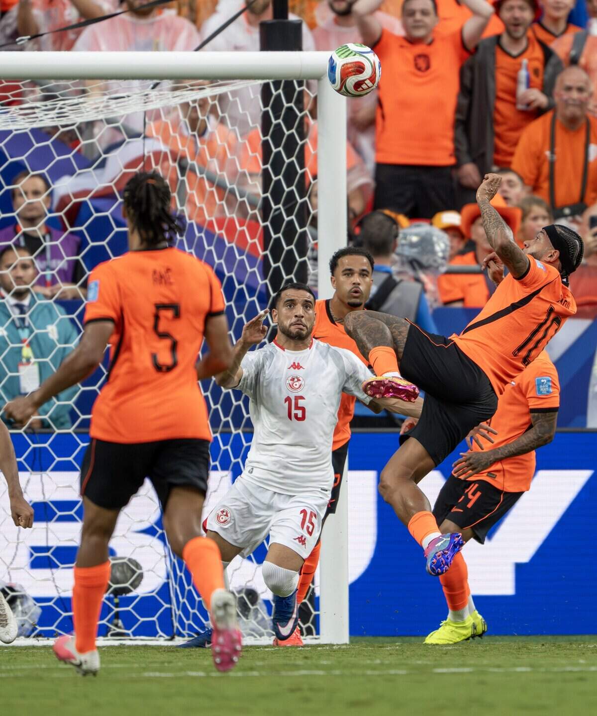 Netherlands forward Memphis Depay (10) and Tunisia midfielder Hadj Mahmoud (15) battle for the ball during the second half of a FIFA World Cup group-stage soccer match at Kansas City Stadium on Thursday, June 25, 2026, in Kansas City.
