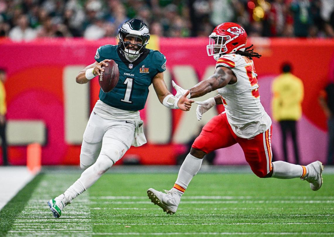 Philadelphia Eagles quarterback Jalen Hurts (1) scrambles past the defense of Kansas City Chiefs defensive end Mike Danna (51) in the fourth quarter during Super Bowl LIX on Sunday, Feb. 9, 2025, in New Orleans.